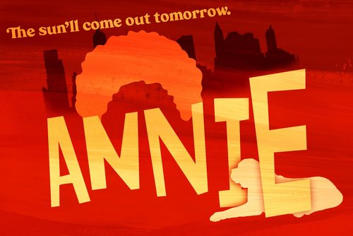 On a reddish background we see the New York City skyline. Above it are the words The sun'll come out tomorrow in orange. Below that is the orange curly hair of the character Annie, and her name in yellow block letters. Among the letters we see the silhouette of her dog, Sandy.