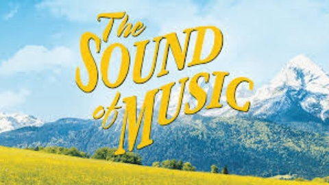 A lovely meadow with the Alps in the background. At center in yellow lettering are the words "The Sound of Music."